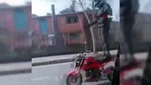 Trafikte motosiklet üzerinde ayağa kalkan sürücü kamerada