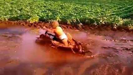 Un gamin s'amuse dans une flaque de boue !