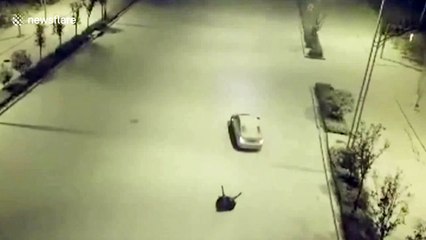 Girl riding tyre gets dragged along snowy road by her father in car in China's Henan