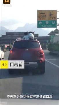 2 enfants assis sur le toit d'une voiture sur l'autoroute