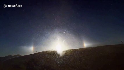 Sundog over snowy hilltop in Minnesota casts brilliant glare during blizzard