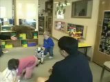 Dos niños intentan poner de pie al robot