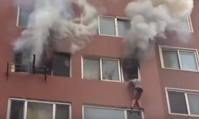 Evi yanan kadın, pencereden sarkarak kurtarılmayı bekledi