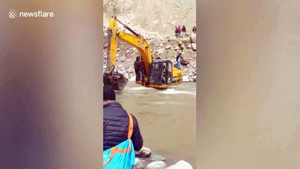 Local people transported by JCB across river to escape landslide in north India