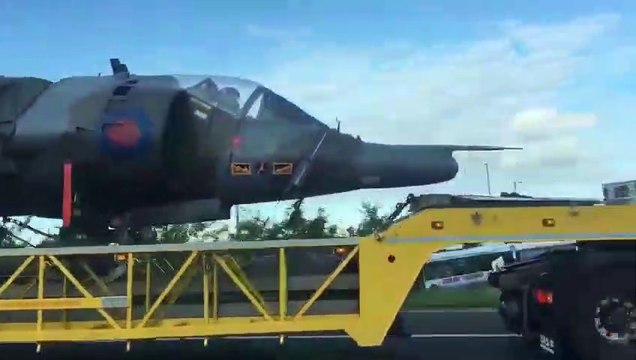 Il y a un pilote dans le cockpit de l'avion transporté sur ce camion !