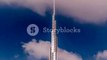 The Burj Khalifa among blue sky with clouds and rays of sun light timelapse, tallest building in the world. Dubai, UAE