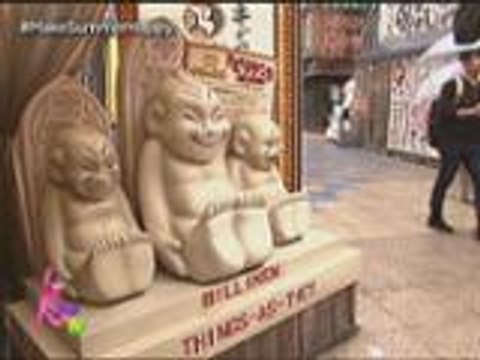 Kris takes a picture beside Billiken