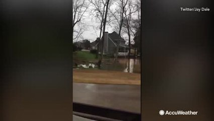 Floodwater spills into golf course after creek breaks its banks