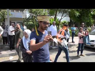 أوائل الخريجين يوزعون المناديل على المواطنين أمام الوزراء