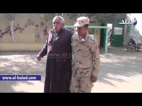 صدى البلد | الجيش يساعد «مسناً» الوصول إلى لجنته الانتخابية بـ الزاوية