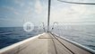 Front view on luxury sailing yacht boat nose with wooden parquet floor, swaying in open sea at sunny day. Relaxing and peaceful background holiday shot