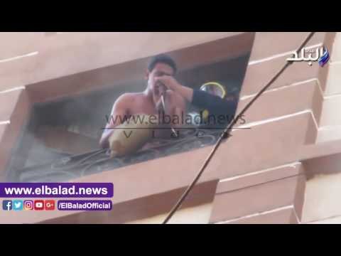 صدى البلد | أمين شرطة ينقذ شاب قبل سقوطه بحريق الفيوم