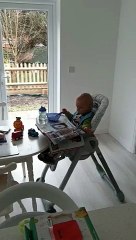 Comme un grand, ce bébé lit le journal pendant le petit-déjeuner