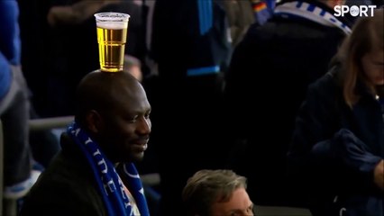 Fan balanciert Bier auf seinem Kopf
