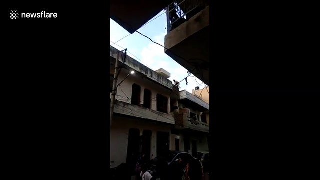 Dumb thief stuck dangling from top of building is rescued by police