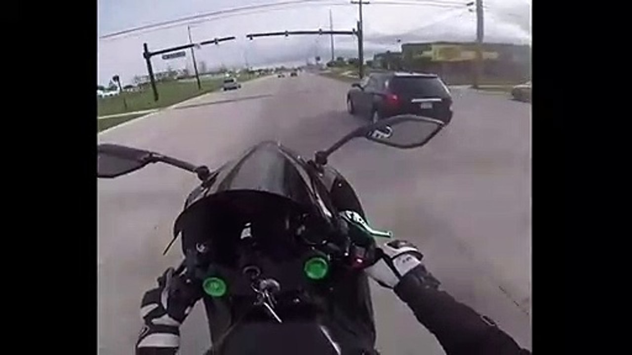 Un motard fait un doigt d'honneur à une voiture de police.