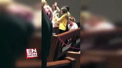 İnsanlar kilisede dua ederken Macarena Dansı yapan ufaklık