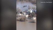 Helicopter rescue of people stranded on rooftop by widespread flooding