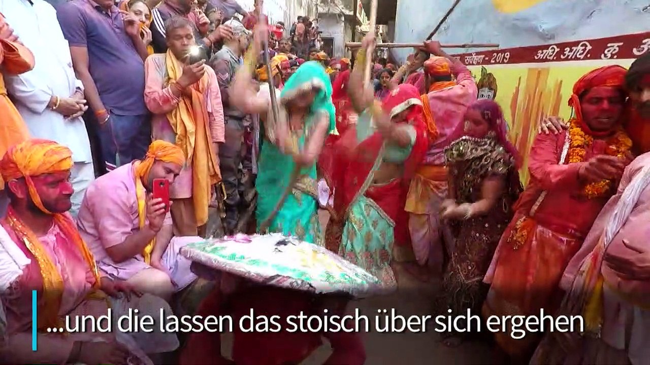 Frauen verdreschen Männer in Indien mit Stöcken