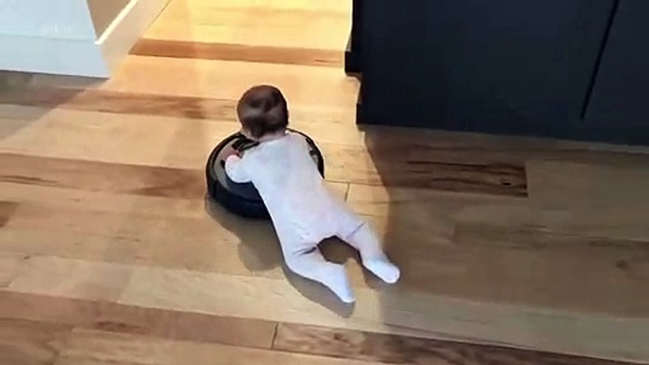 Un bébé s'amuse sur un aspirateur roomba... Trop mignon