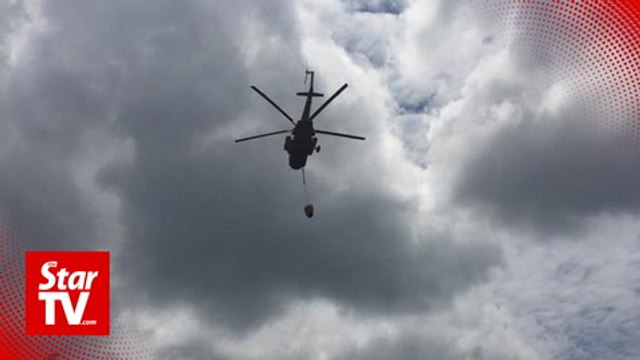 Firemen use water-bombing to fight raging forest fires in Limbang