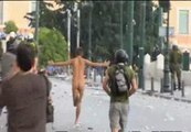 Un manifestante corre desnudo ante los antidisturbios en Atenas