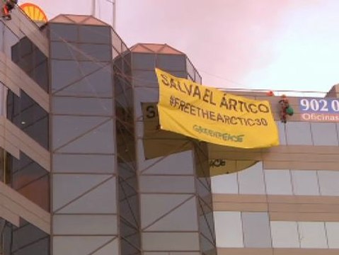 Activistas de Greenpeace protestan descolgándose de la fachada de Shell en Madrid