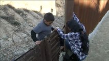 Una familia salta una valla fronteriza en Tijuana (México)