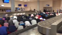 Los musulmanes atrapados en el aeropuerto de Dallas por el decreto de Trump, rezan en la zona de equipajes