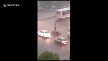 Neither wind nor rain stops this Indian traffic cop from doing his job