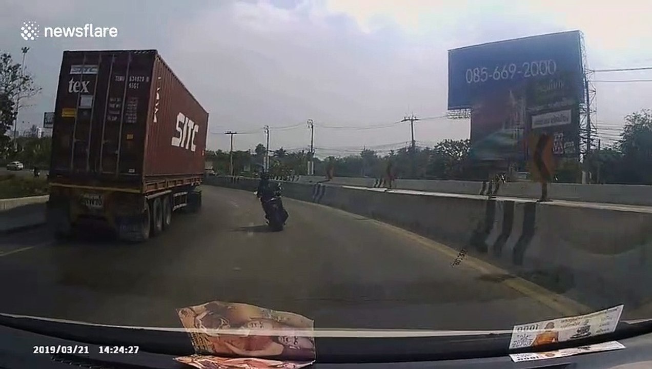 Quick-thinking motorbike rider narrowly avoids being crushed by 40ft long shipping container