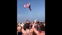 Complètement ivre, elle tente de monter au sommet d'un drapeau sur la plage !