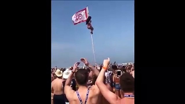 Complètement ivre, elle tente de monter au sommet d'un drapeau sur la plage !