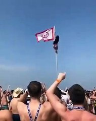 Une jeune femme ivre tente de monter au sommet d’un drapeau