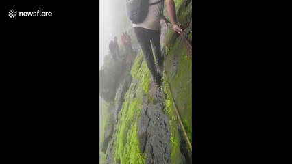 Trekker shows off terrifyingly slippery climb along cliff edge in west India