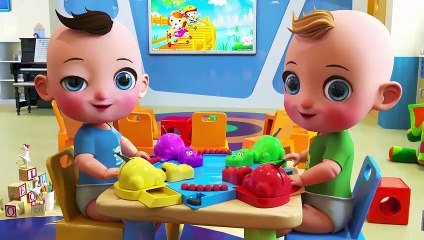 Two babies are showing how to play hungry hippos who eat the colorful balls