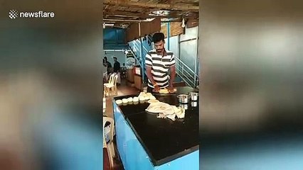 Indian paratha cook casually tosses dough over his shoulder to other chef