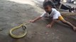 Cet enfant joue avec un serpent très agressif... même pas peur