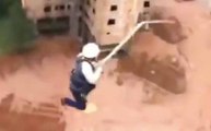 Des ouvriers font du saut à l'élastique sur le chantier pendant la pause déj