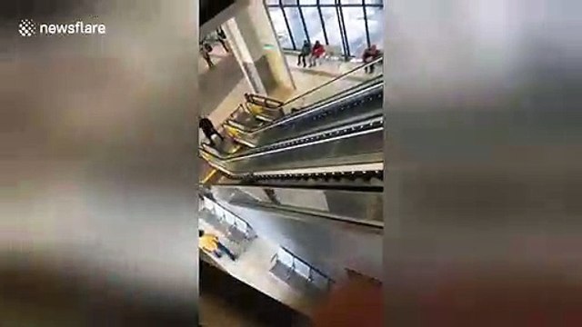 Packed for the holidays? Girl drops suitcase down escalator waving goodbye at airport