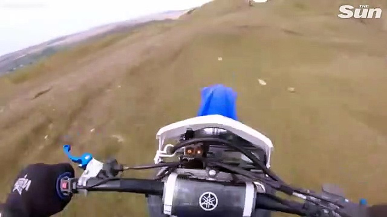 Un biker fait une énorme chute d'une falaise à motocross et s'en sort par miracle