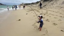 Un petit garçon pêche cet énorme poisson