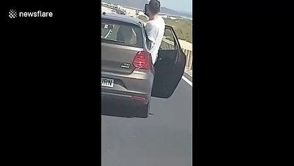 Reckless passenger leans from car door to take selfie on busy road in the Canary Islands