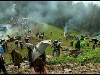 Masses of pilgrims with umbrellas walking the high meadows...