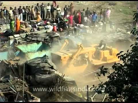 Demolishing the box and board houses of the slum-dwellers