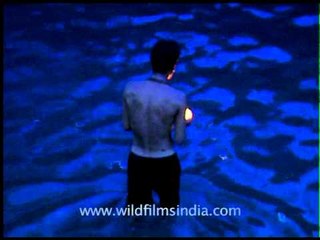 Devotee offering a lighted lamp to river Pampa in Sabarimala
