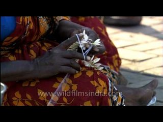 South Indian woman making Gajra (flower garland)