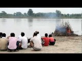 People watch while a dead person burns: Hindu cremation ceremony, Vrindavan