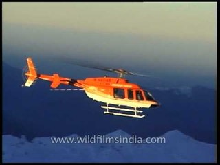 Helicopter racing over the high peaks of the Himalaya
