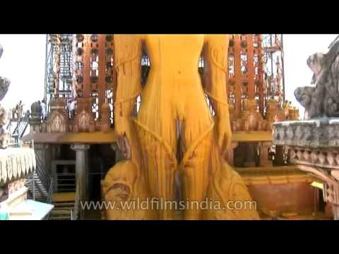 Devotees pouring turmeric and sandal wood paste on the head of Lord Gomateshwara